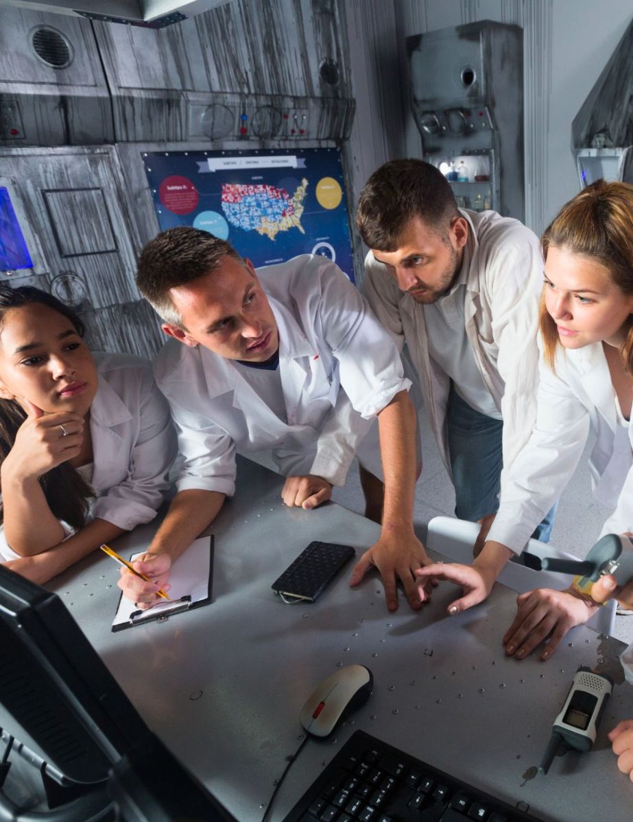 Group of friends solving clues together at a table in a Black Hills escape room