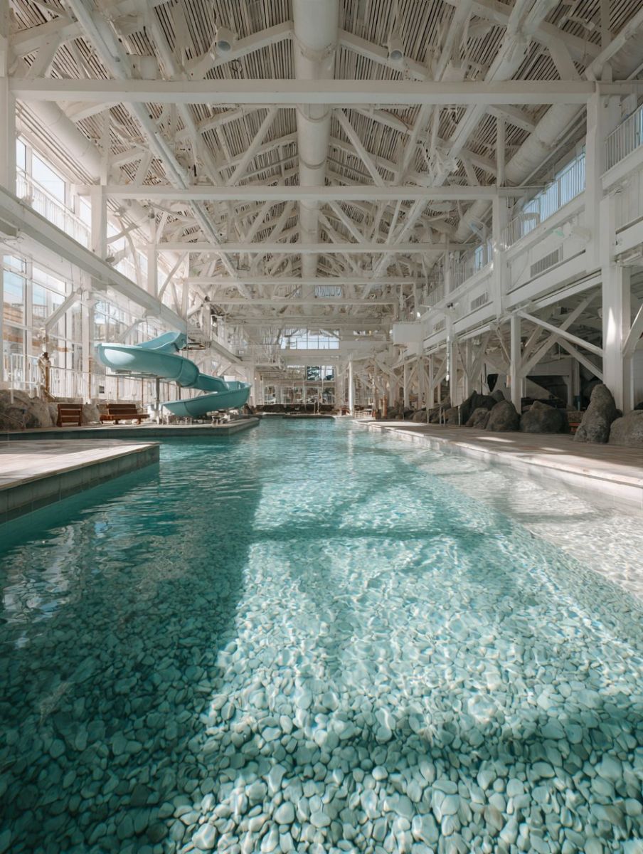 Indoor thermal spring pool with a pebble bottom and water slide in Hot Springs